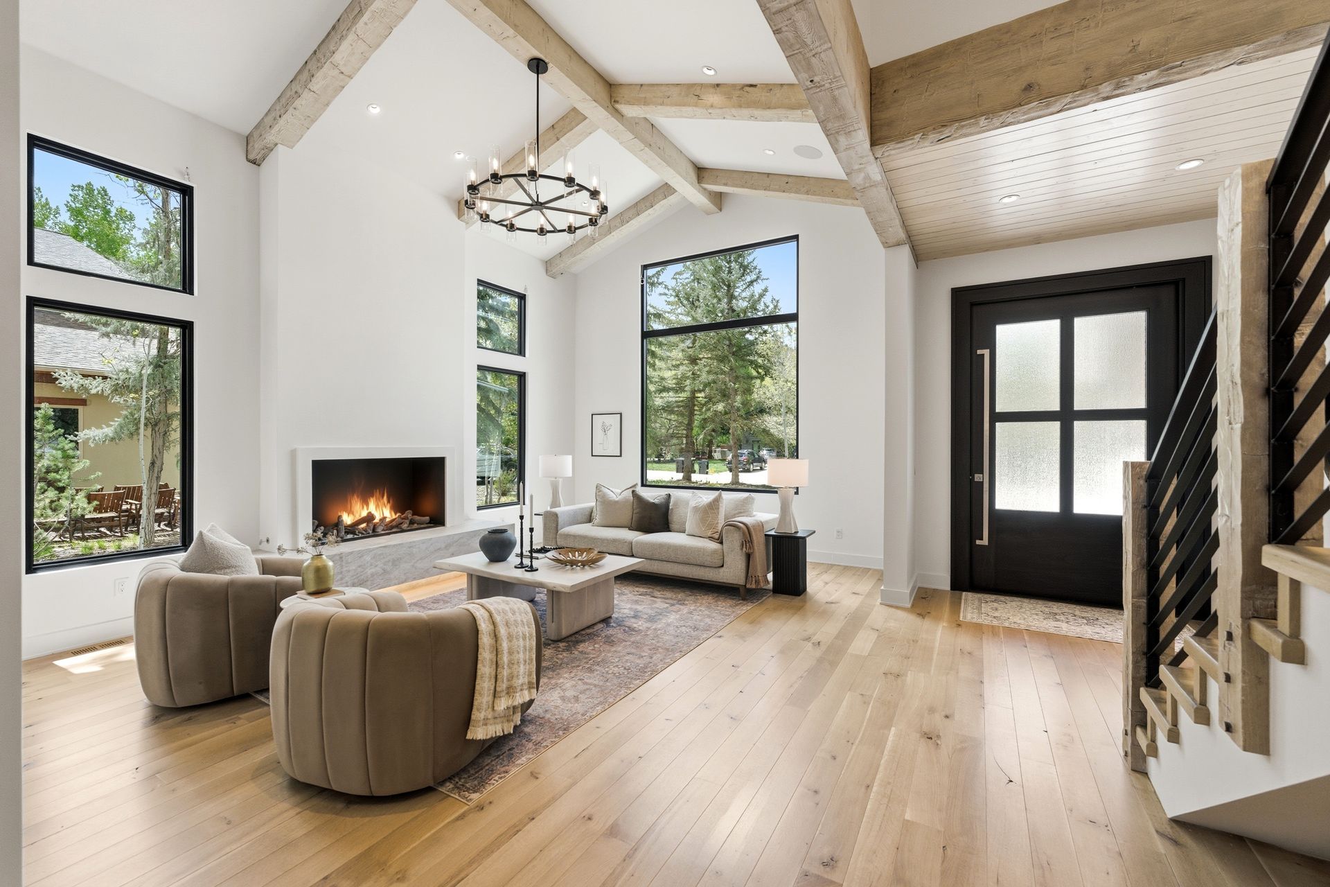 Spacious great room with vaulted ceilings, custom white oak flooring, and reclaimed brick fireplace in a Park City luxury home.