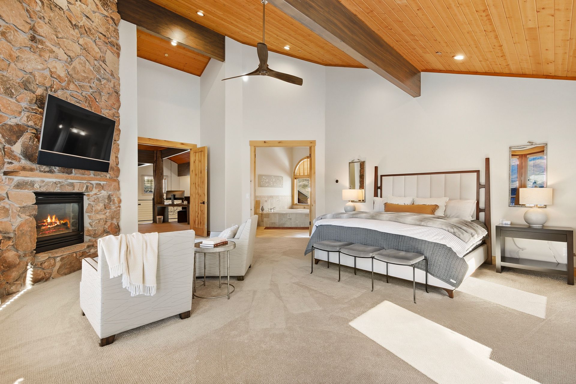 Spacious primary suite retreat featuring vaulted ceilings, fireplace, and private mountain views.