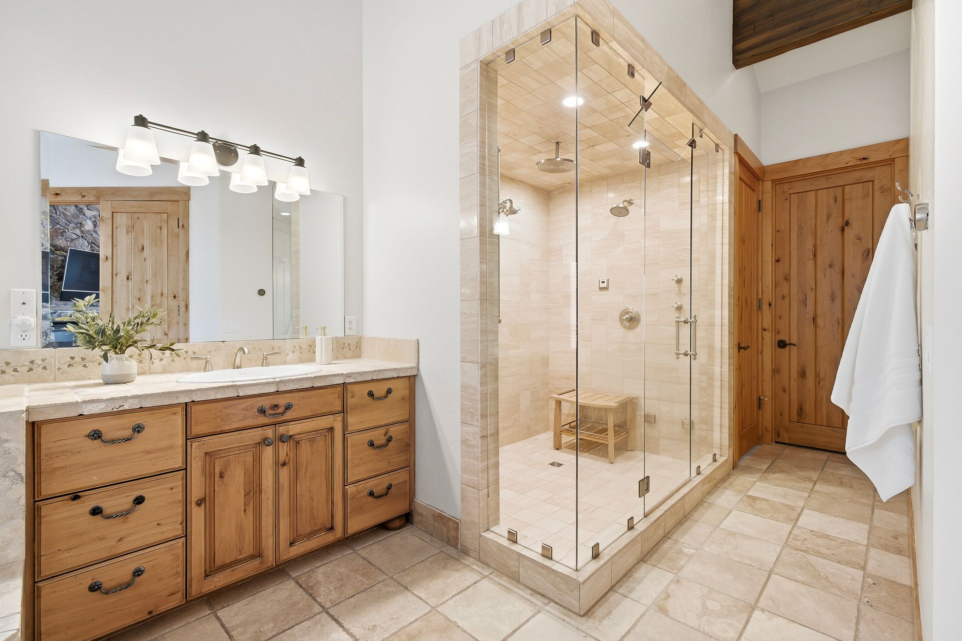 Walk-in steam shower with glass enclosure and custom stone tile work.