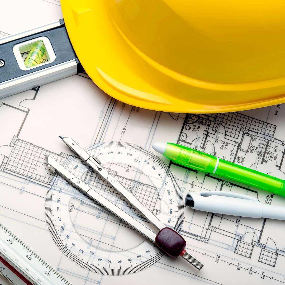 Architectural house blueprints with a hard hat and compass, illustrating the due diligence and home inspection process for a real estate purchase.