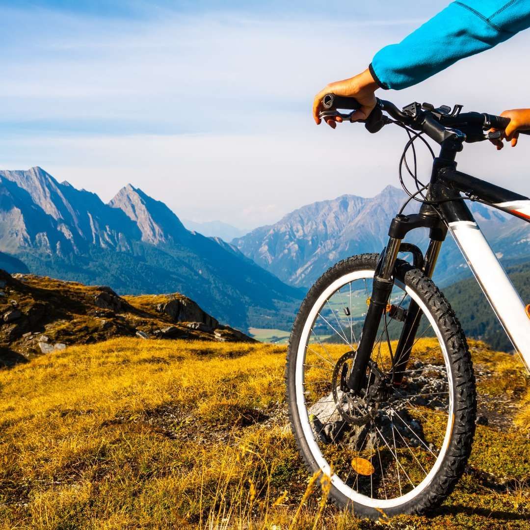 A mountain bike wheel overlooking the scenic Wasatch Back mountains, highlighting the outdoor summer lifestyle of Park City, Utah.