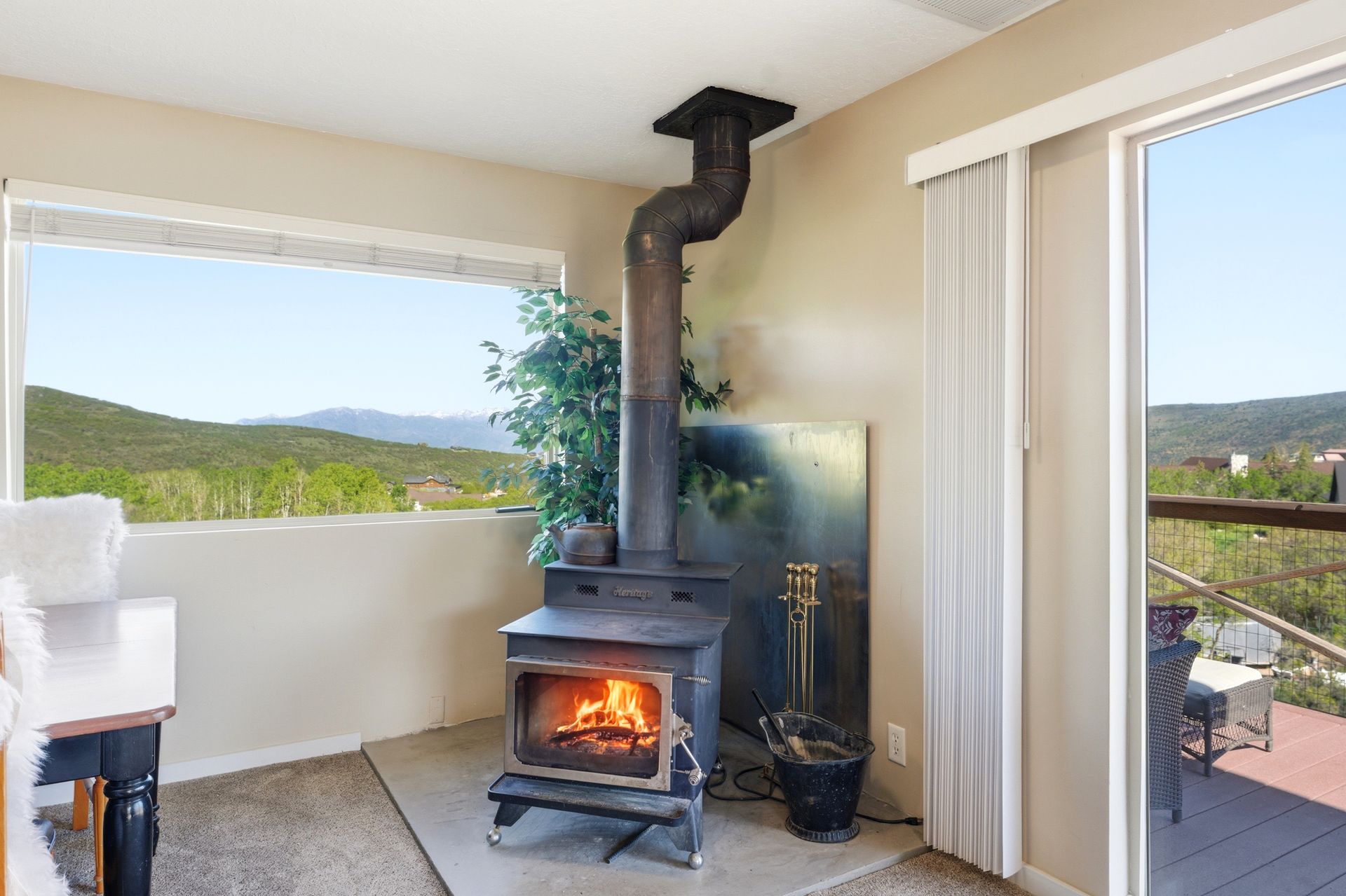 Main living room featuring architectural wood ceilings, a Heritage wood stove, and expansive mountain views.