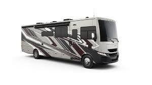 Gray and black RV with a patterned design, parked on a white background.
