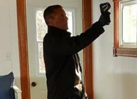 A man is taking thermal tempurature with a thermometer.
