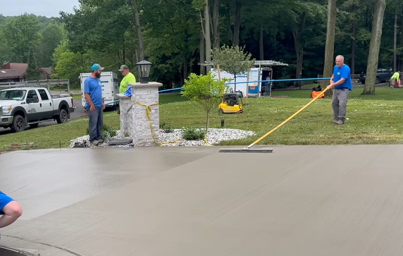 Crew adding broom texture to new concrete driveway.