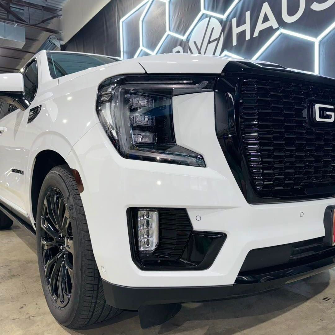 A white gmc truck is parked in front of a bauhaus sign