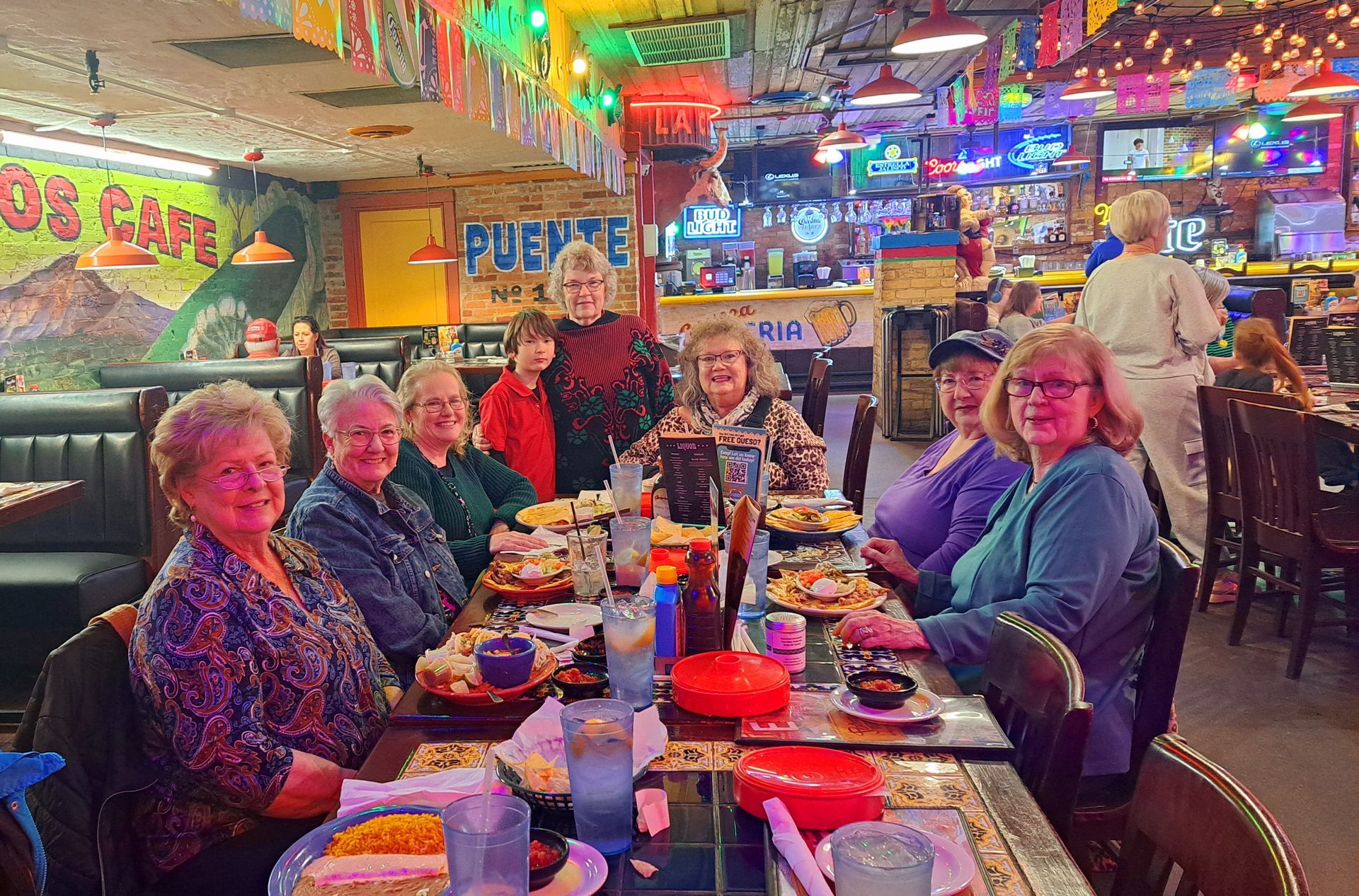 A group of people seated at a table in a brightly lit Mexican restaurant.