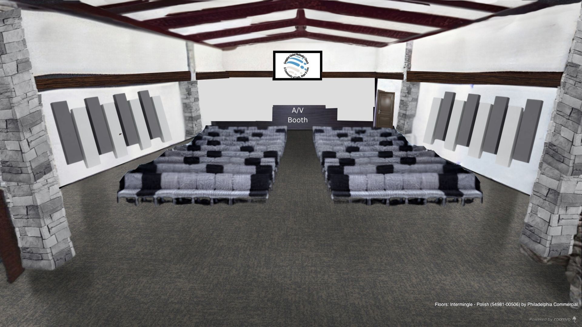 Auditorium with rows of seating, stage with screen, stone columns, and white ceiling.