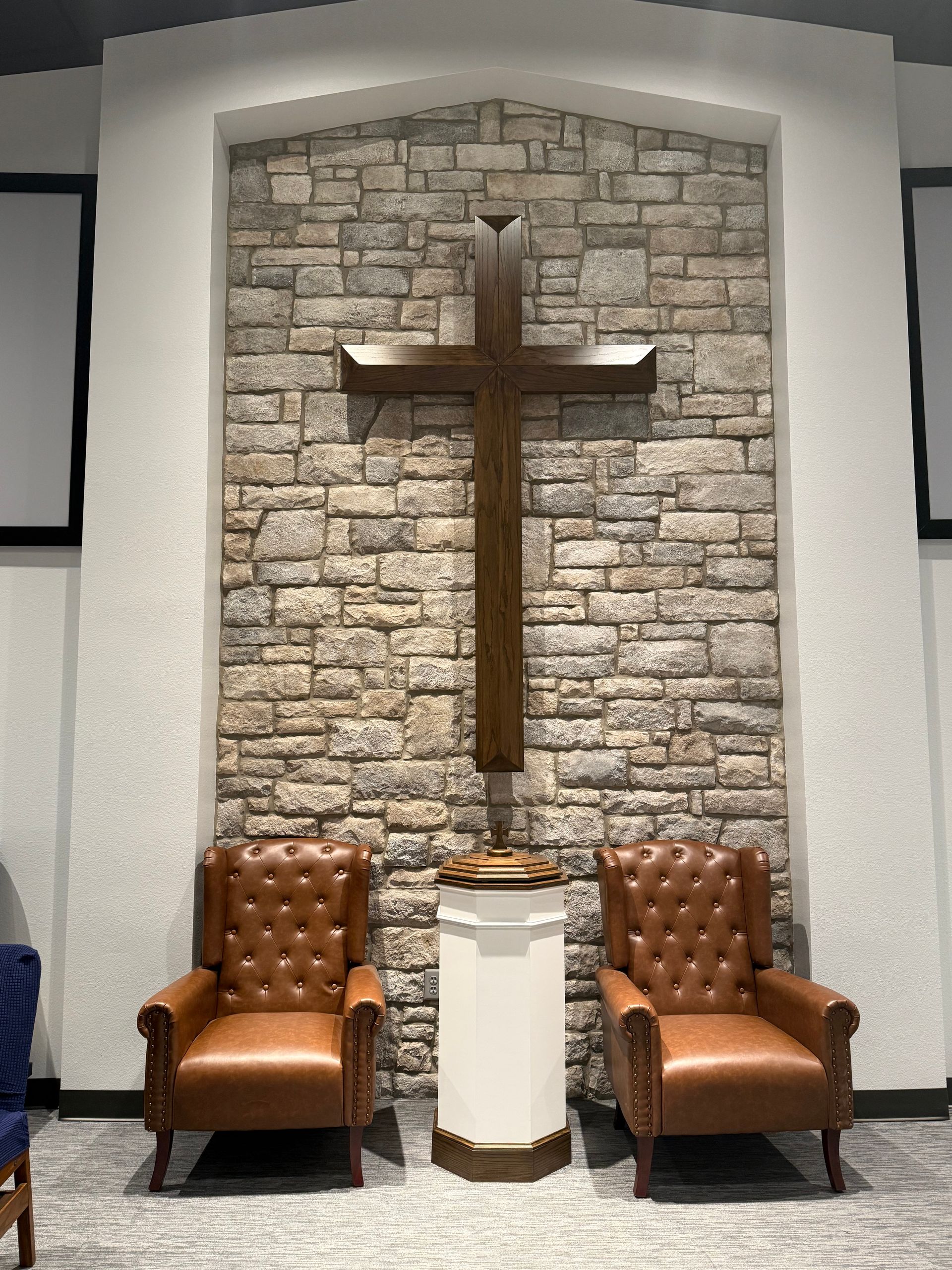 Altar with a cross, candle, wine, bread, and microphone, likely for a religious service.