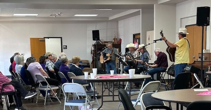 Band performing country music for an audience in a community center.