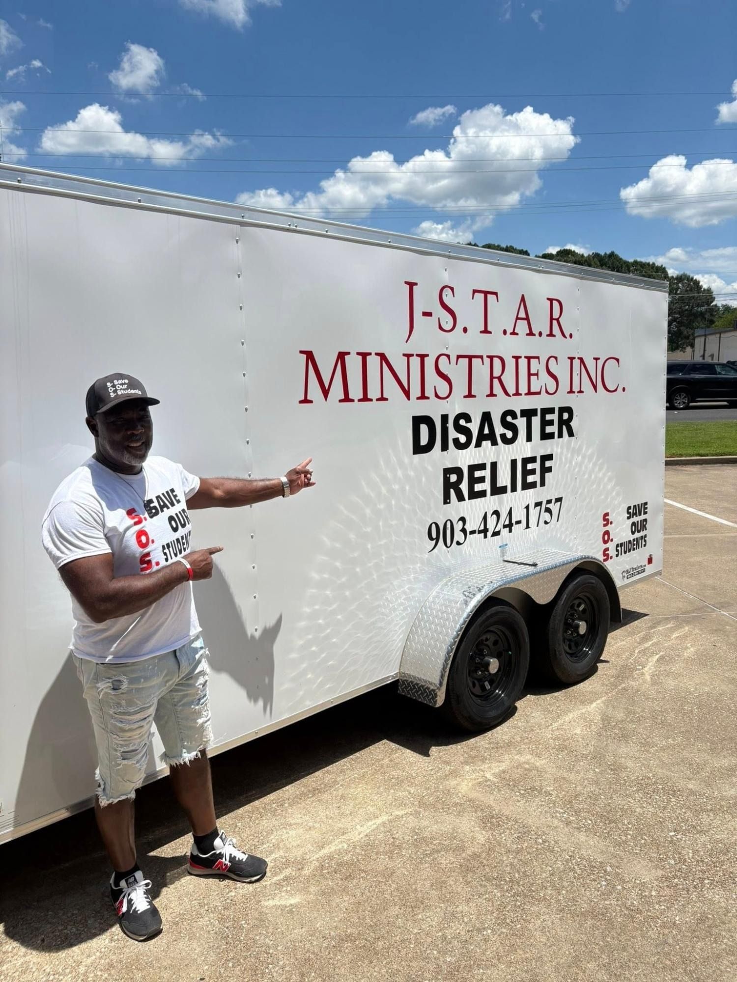 Man points to a white trailer with 