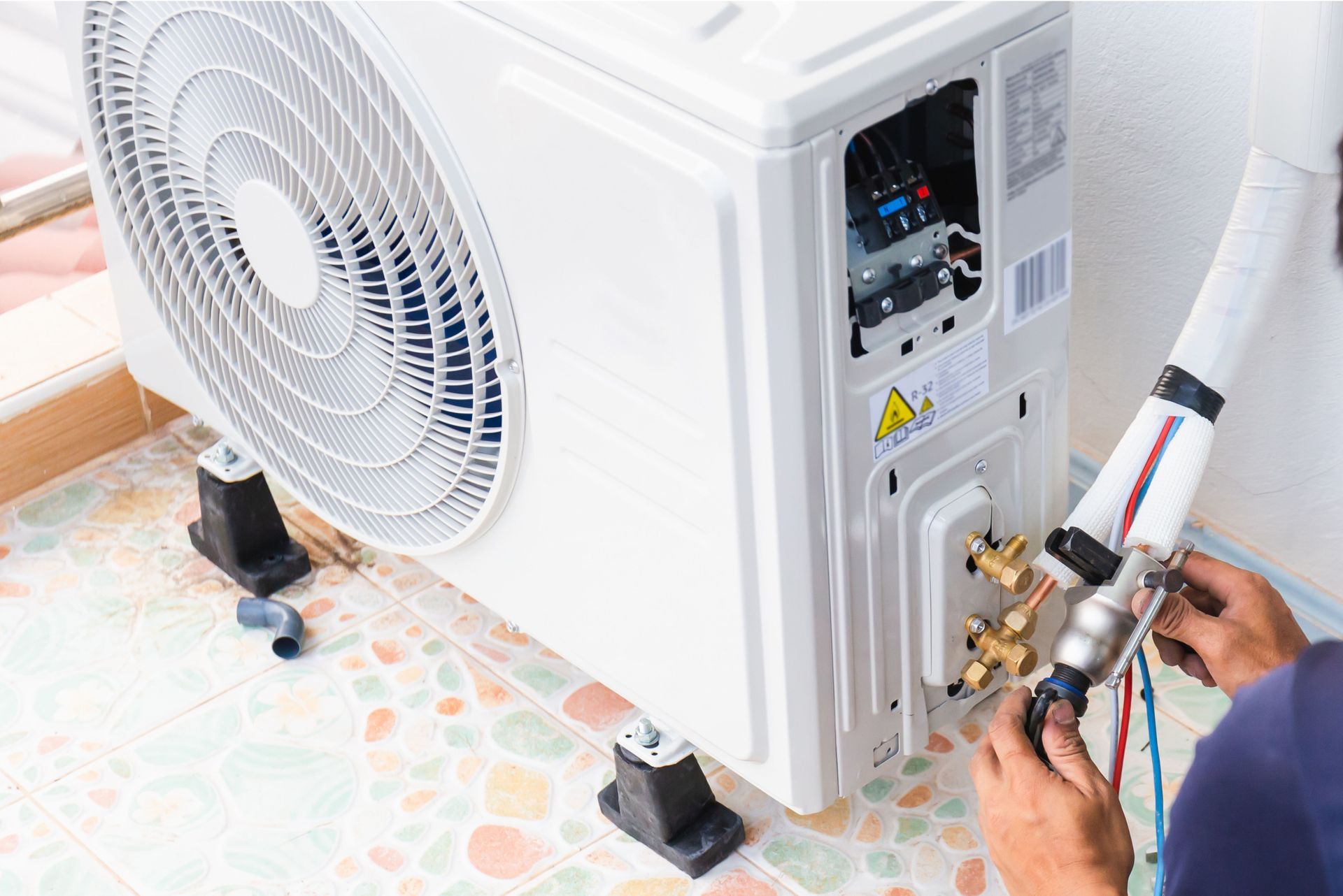 A man is working on an air conditioner in a room.