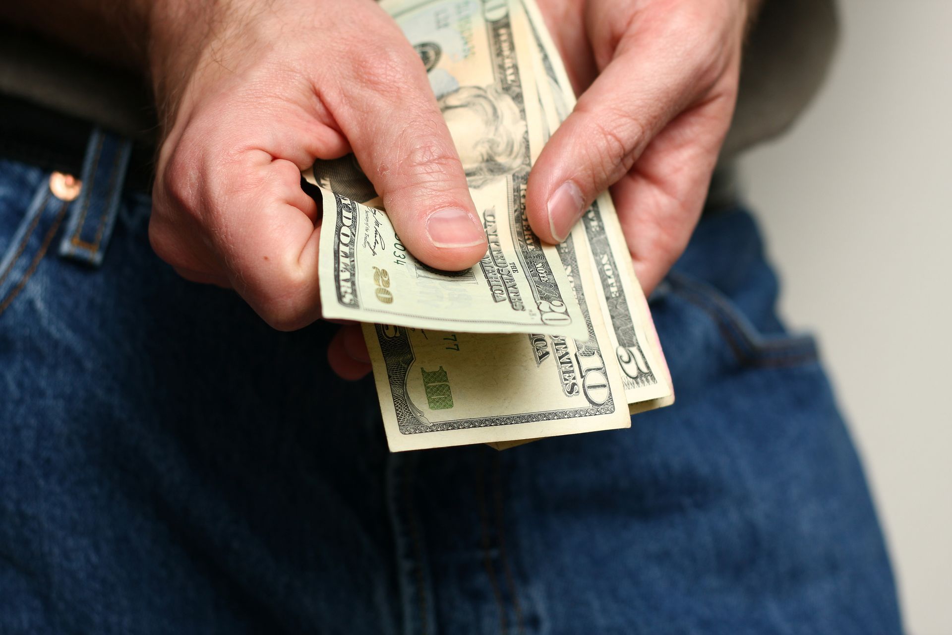 Person counting cash for quick cash needs from payday loan services.
