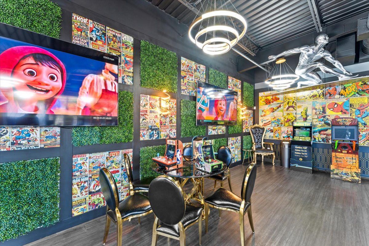 Super Dentists  in San Antonio  A room with a table and chairs and a lot of televisions on the wall.