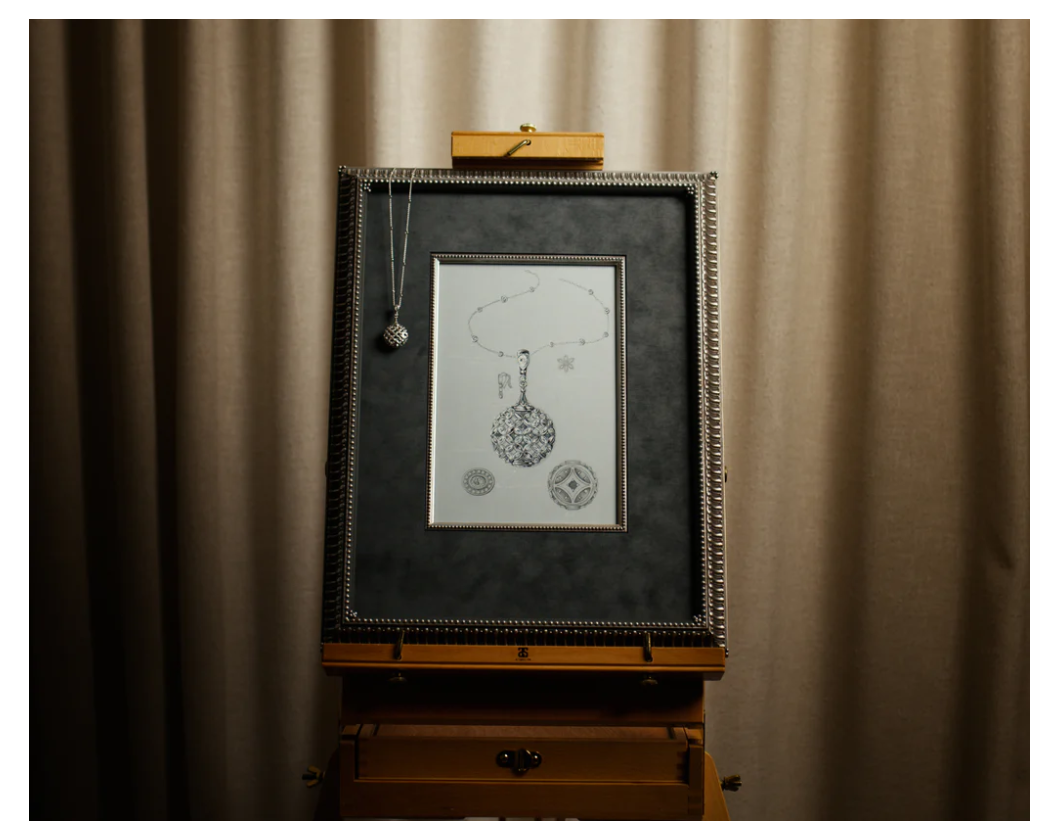 Framed pencil illustration of a pendant on an easel with the finished necklace hanging  over it.