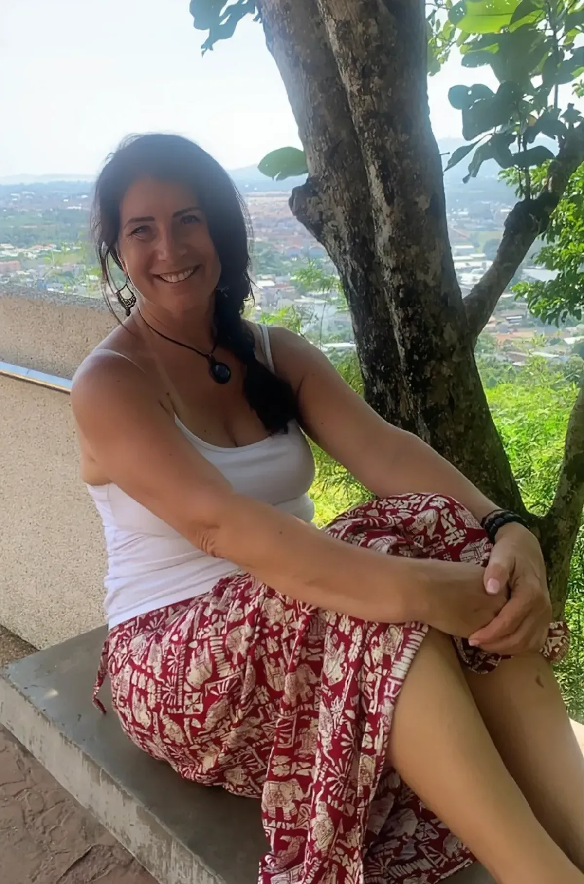 Paula on a bench overlooking a tropical city