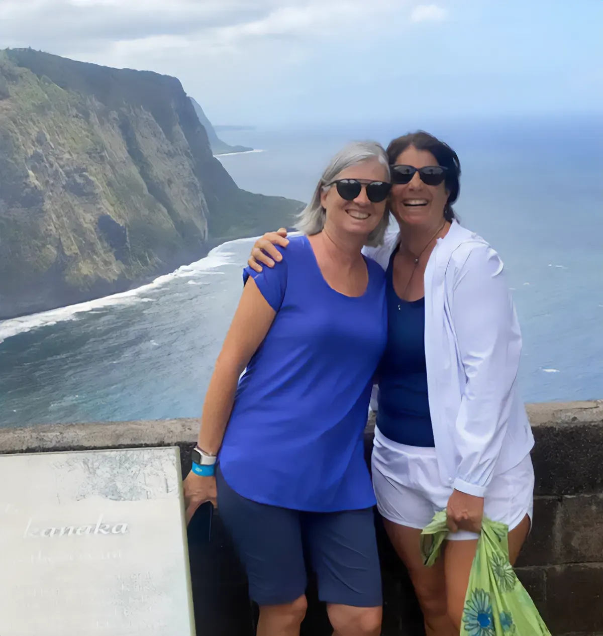 two friends posing for a picture overlooking coastal cliffs