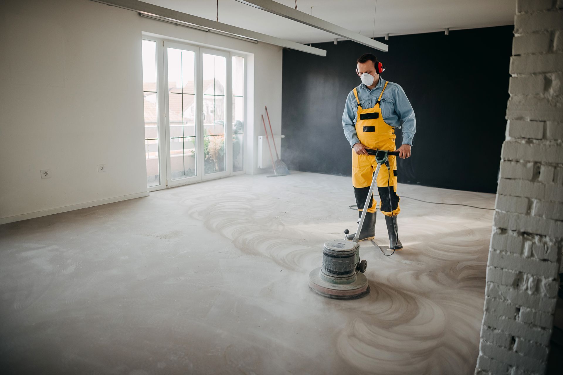 A flooring contractor working on a residential concrete polishing project.