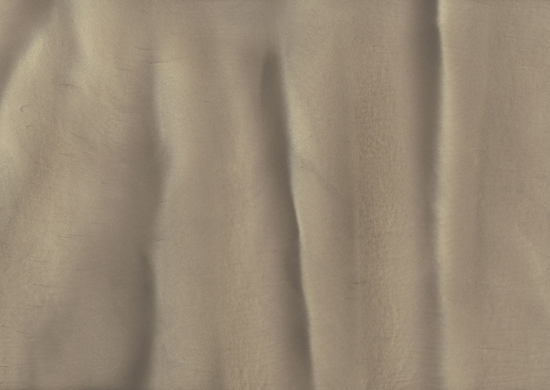 Close-up of wrinkled, textured fabric in a muted olive green color. Vertical folds create shadows and highlights.