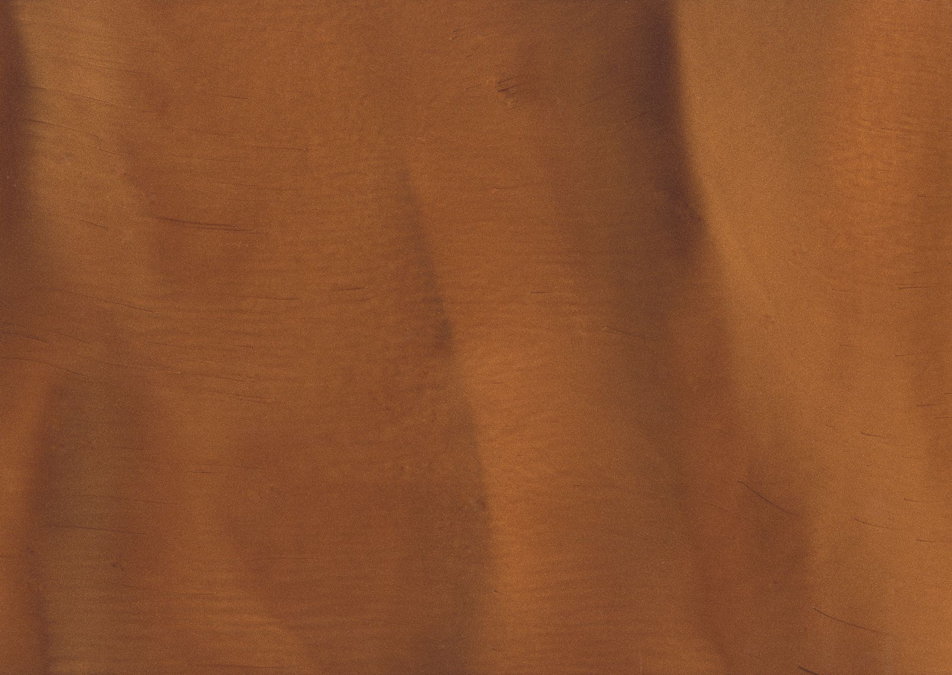 Close-up of textured, grainy, brown fabric with light and dark areas creating an abstract pattern.