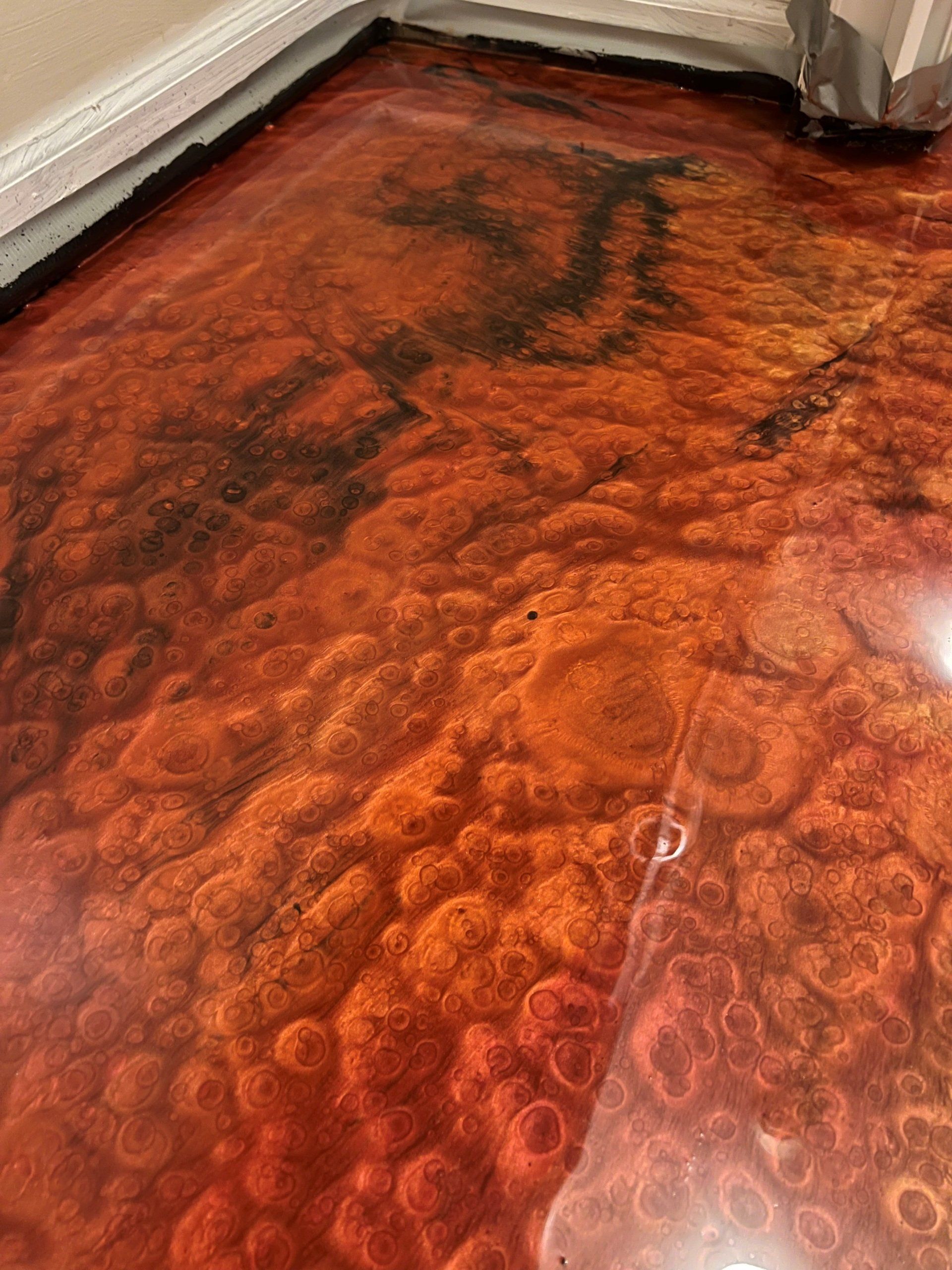 Metallic orange and black epoxy floor with a textured, bubbled appearance.