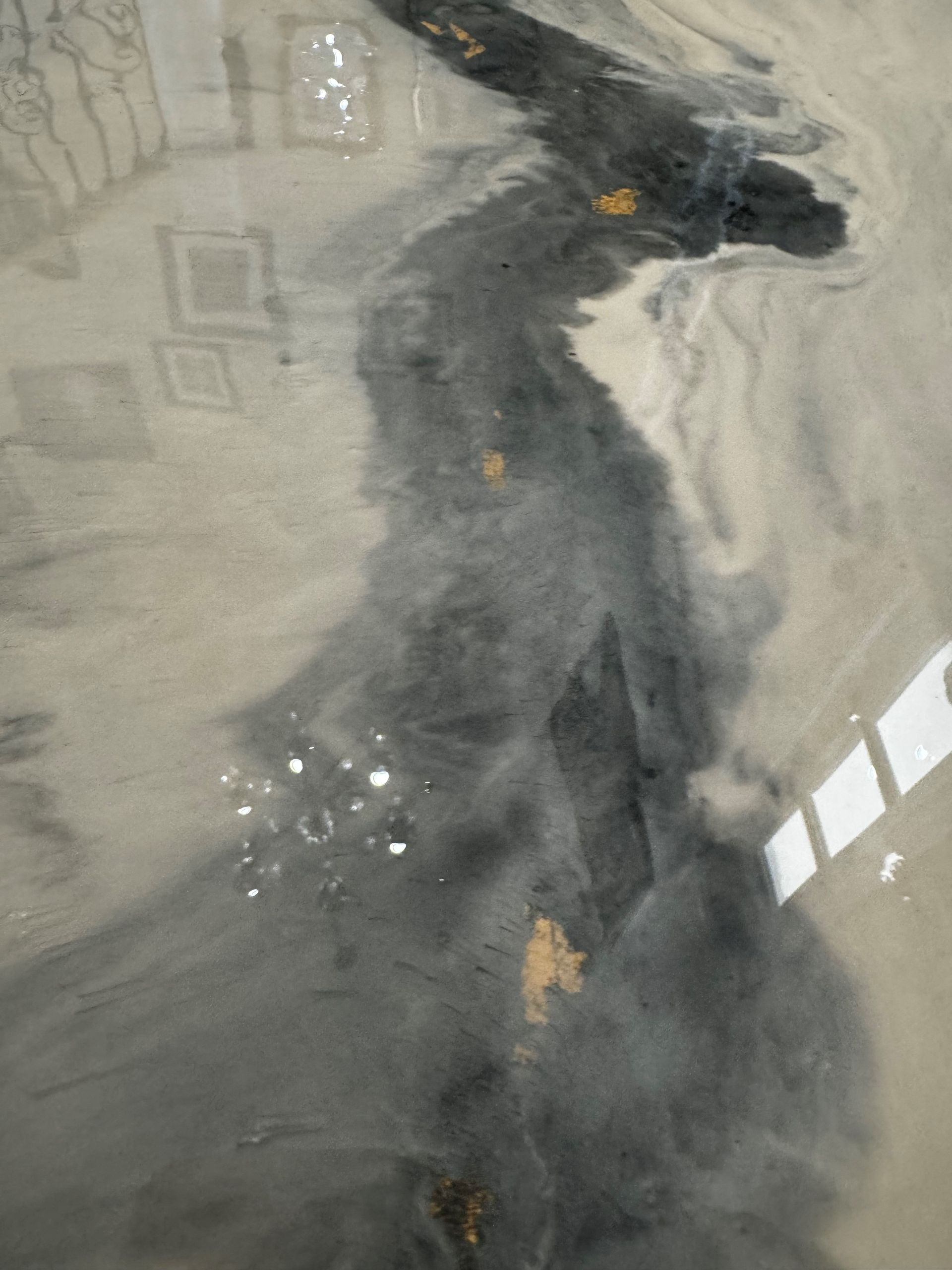 Abstract design with dark gray, fluid-like patterns against a light gray background. Some gold flecks and a light reflection.