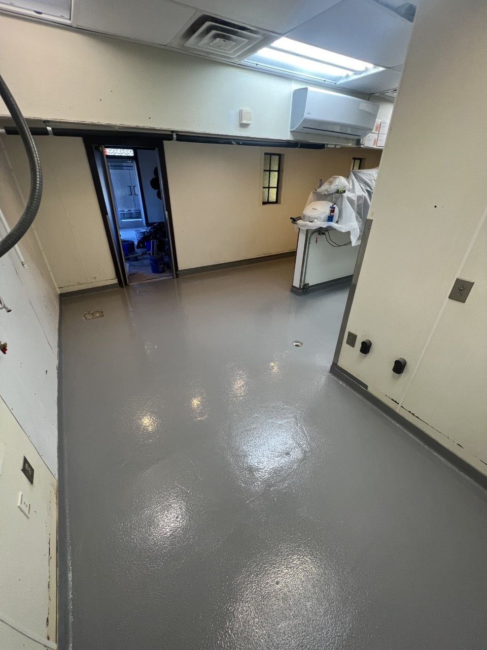 A room with a gray floor and white walls.