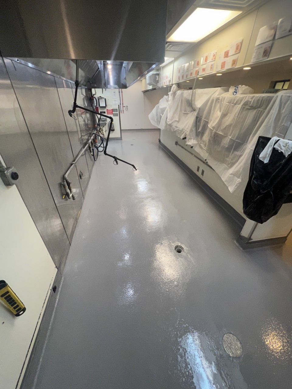 A kitchen with stainless steel appliances and a gray floor
