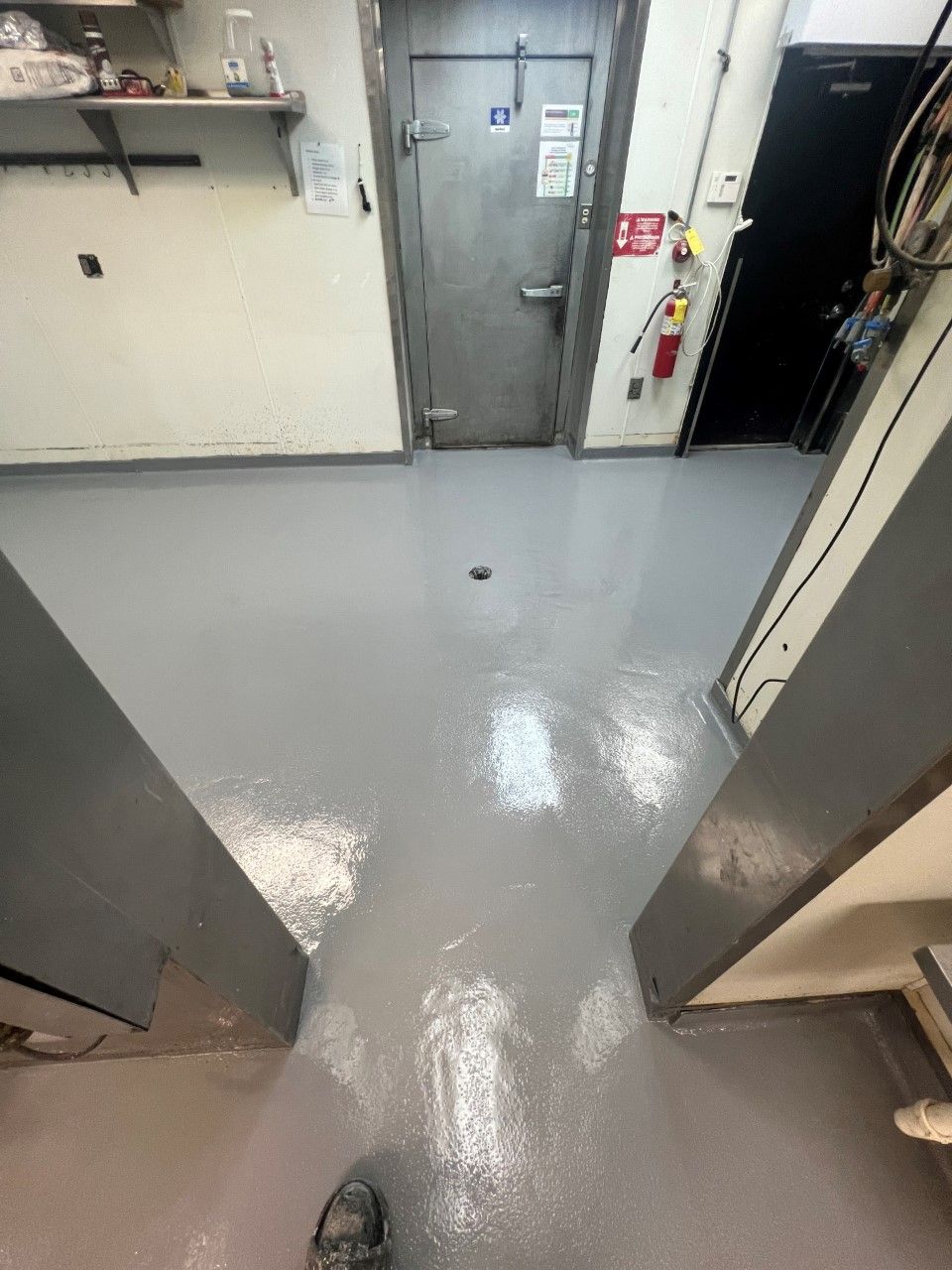 A person is standing on a concrete floor in a room.