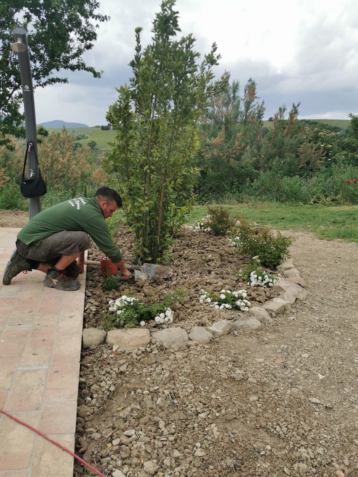 Un uomo con una camicia verde sta lavorando in un giardino