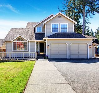 A house with two garage doors and a sidewalk in front of it