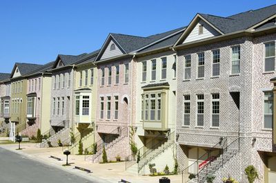 A row of houses on a sunny day with a blue sky in the background