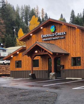 A wooden building with a sign that says Emerald Creek Insurance Agency, LLC