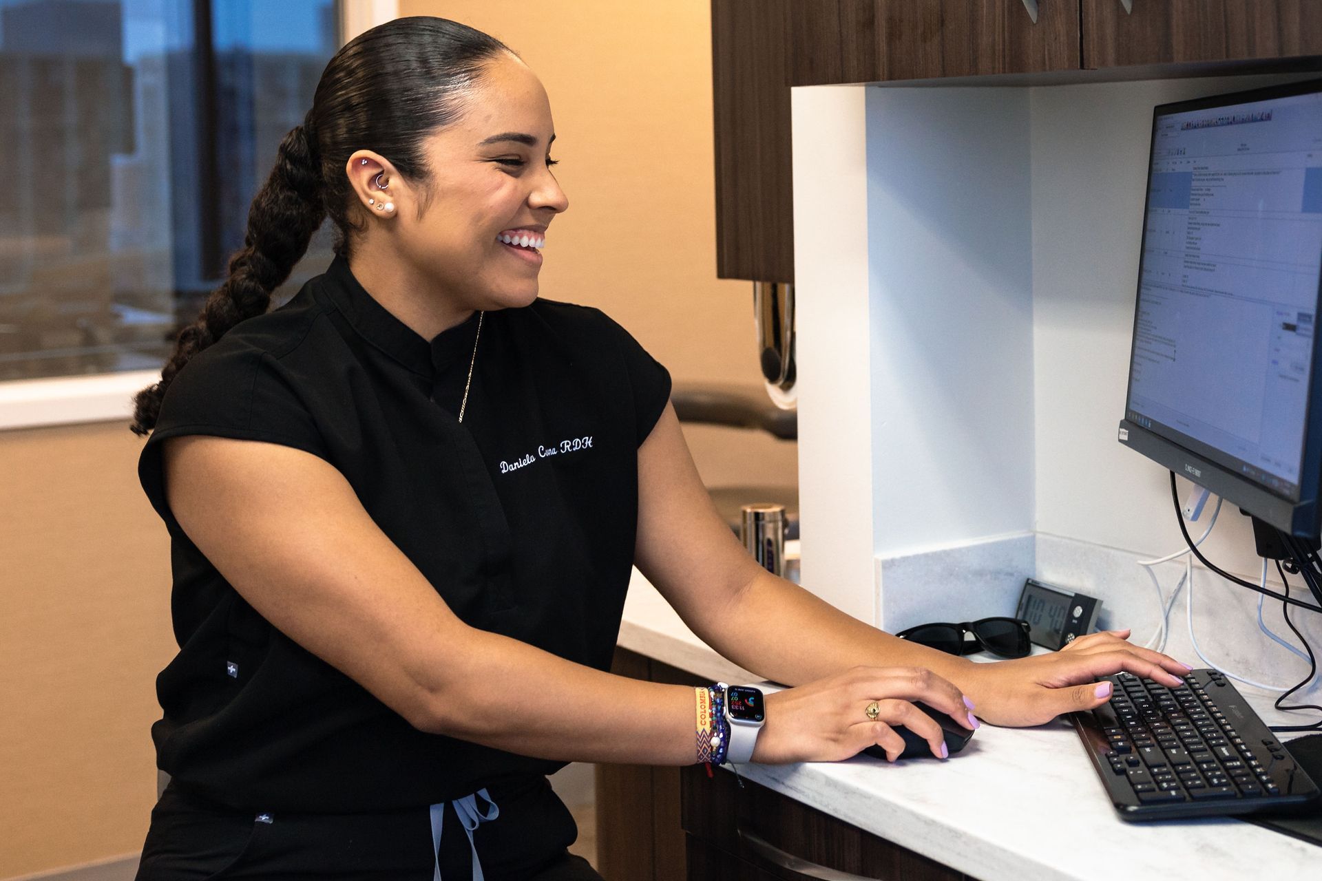 a dental hygienist typing on a computer