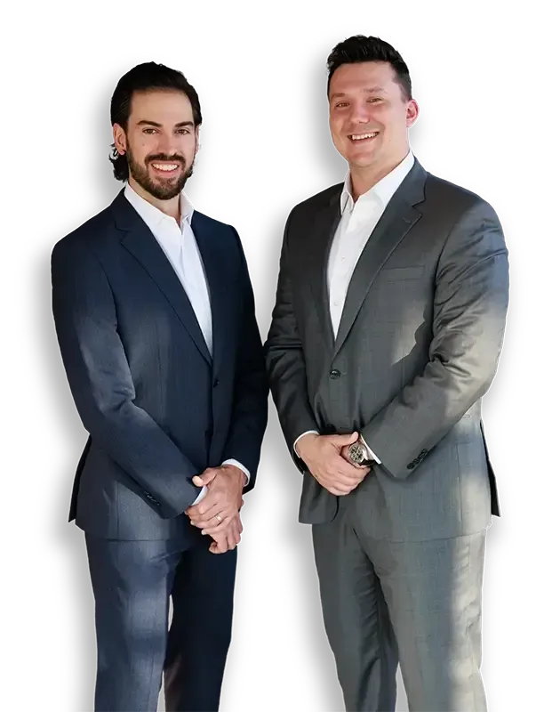 Two men in suits are standing next to each other and smiling.