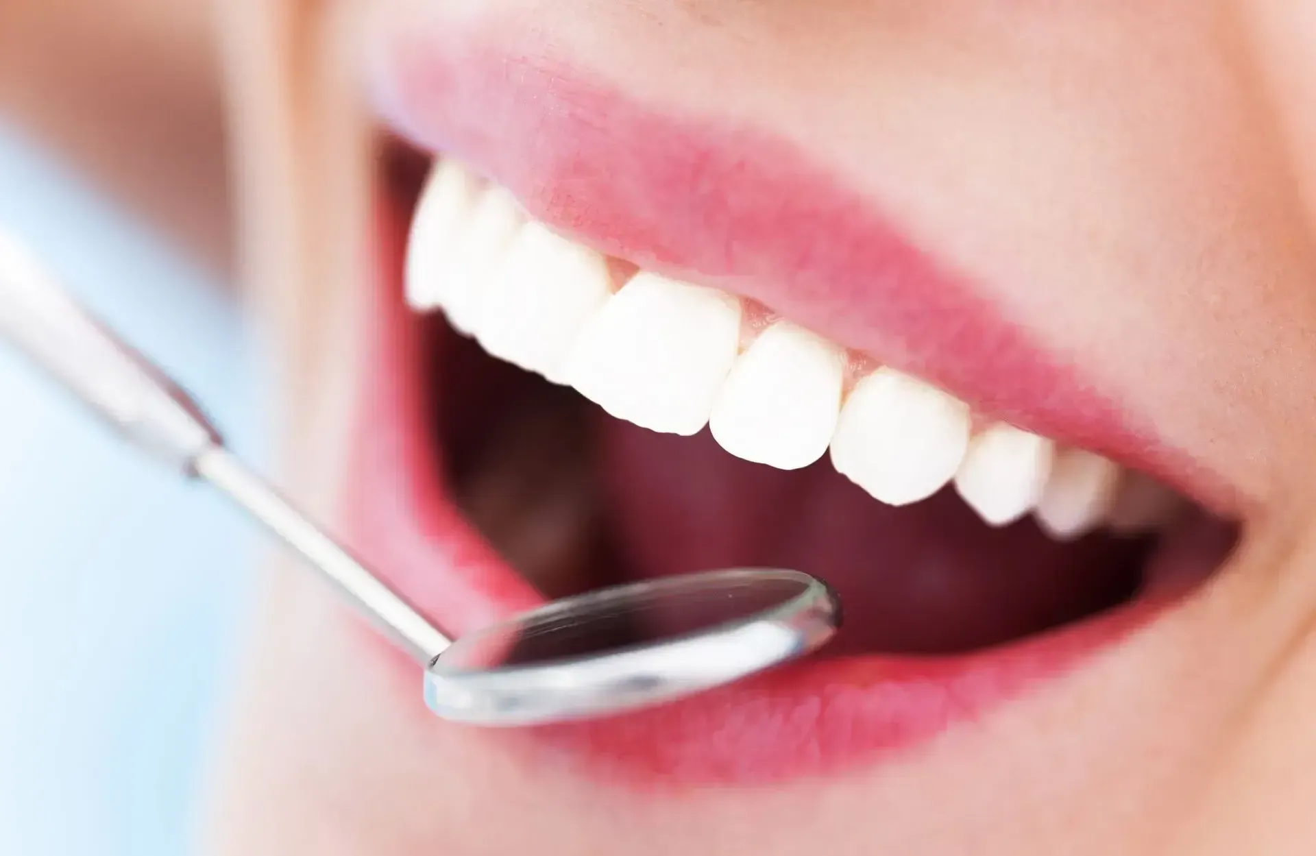 A woman is getting her teeth examined by a dentist.