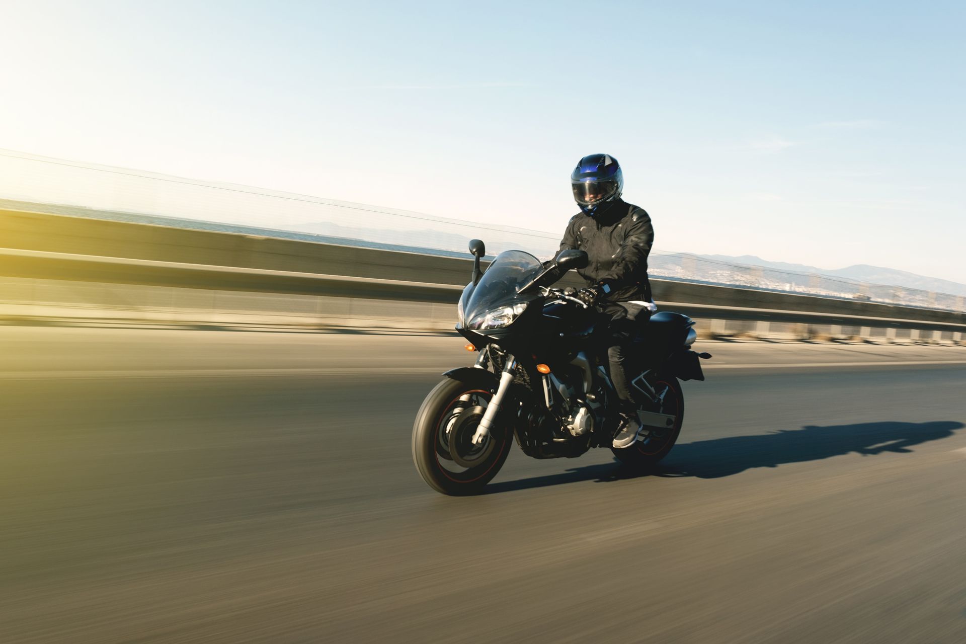 A man is riding a motorcycle down a highway