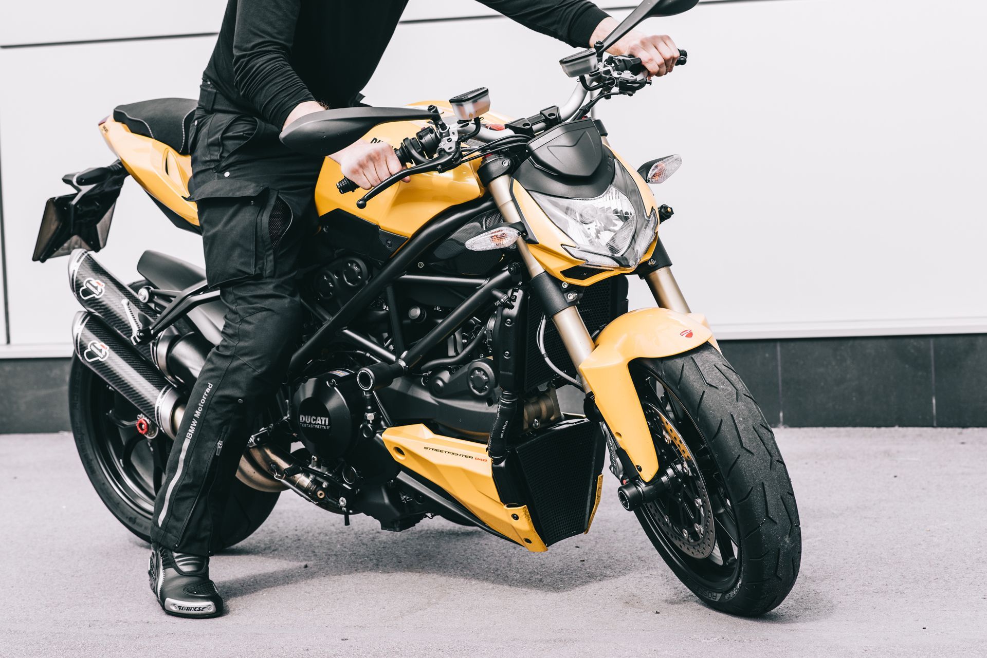 A man is standing next to a yellow motorcycle