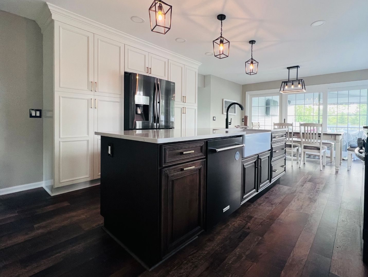 A kitchen with a large island , a refrigerator , a sink , and a dishwasher.