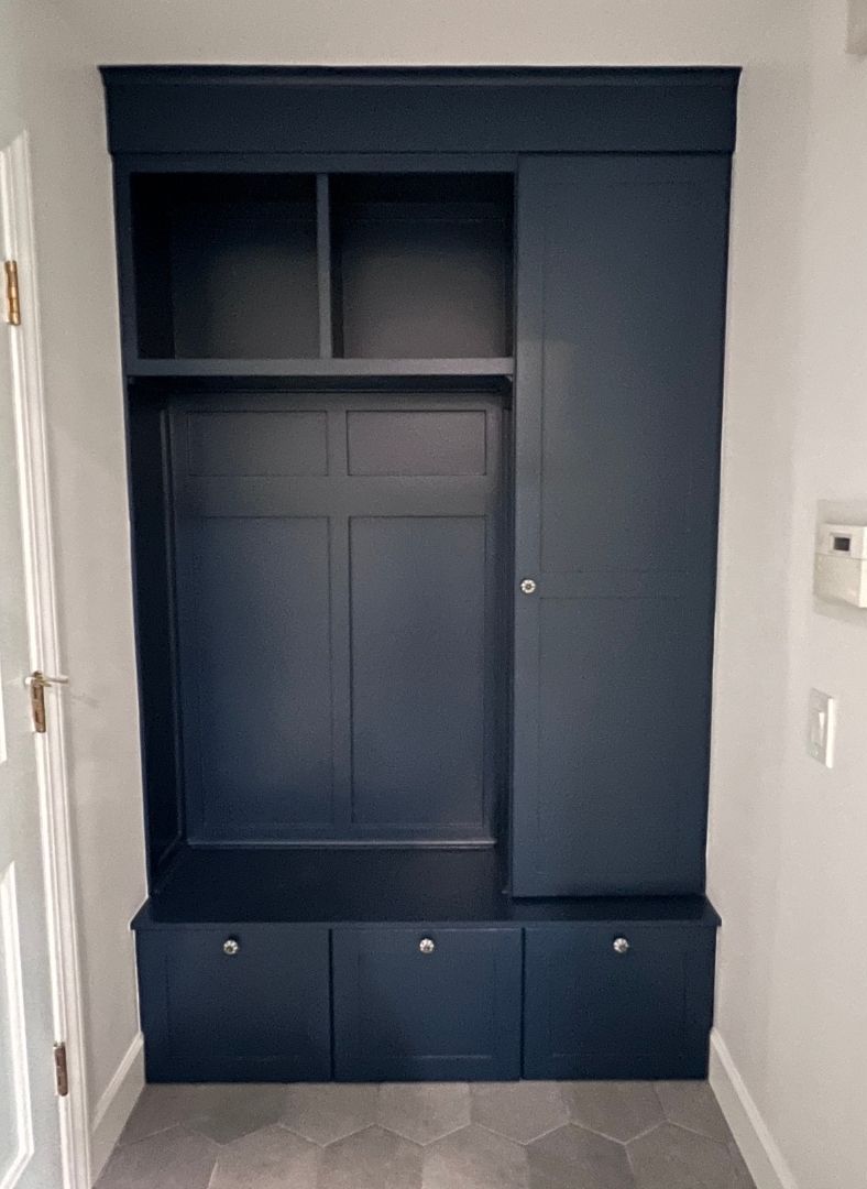 A hallway with a blue cabinet and shelves
