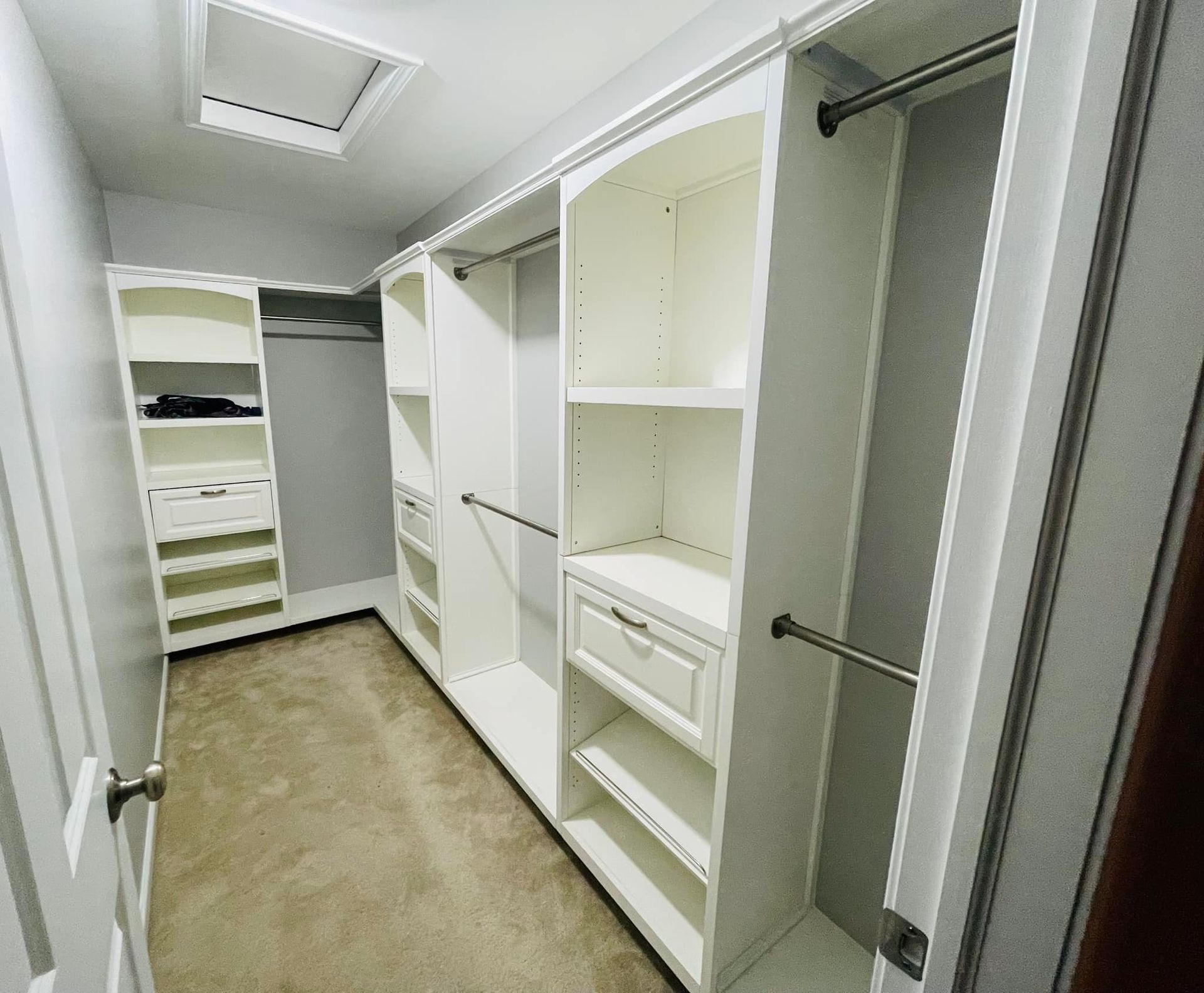 A walk in closet with lots of shelves and drawers
