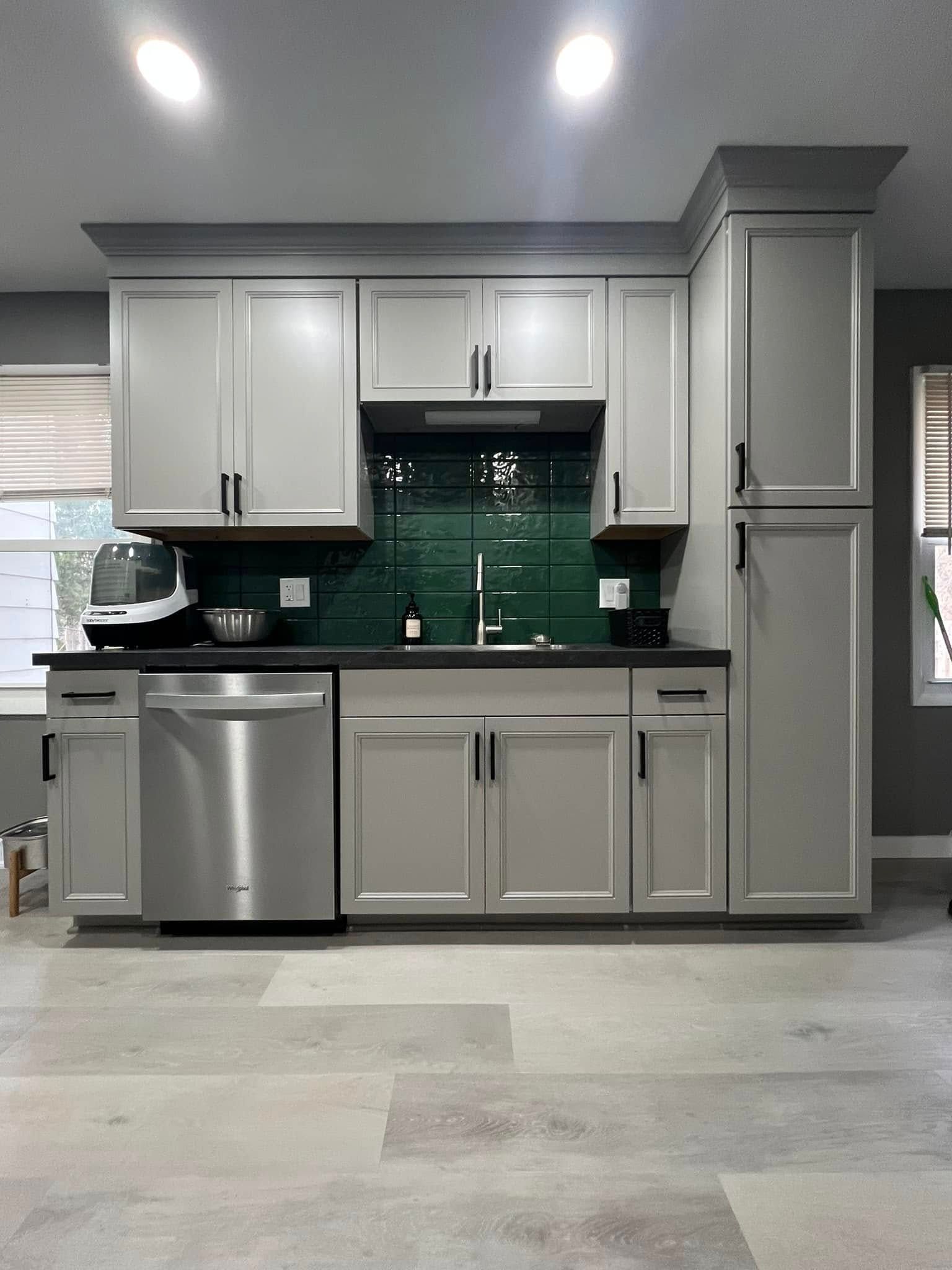 A kitchen with white cabinets and a stainless steel dishwasher