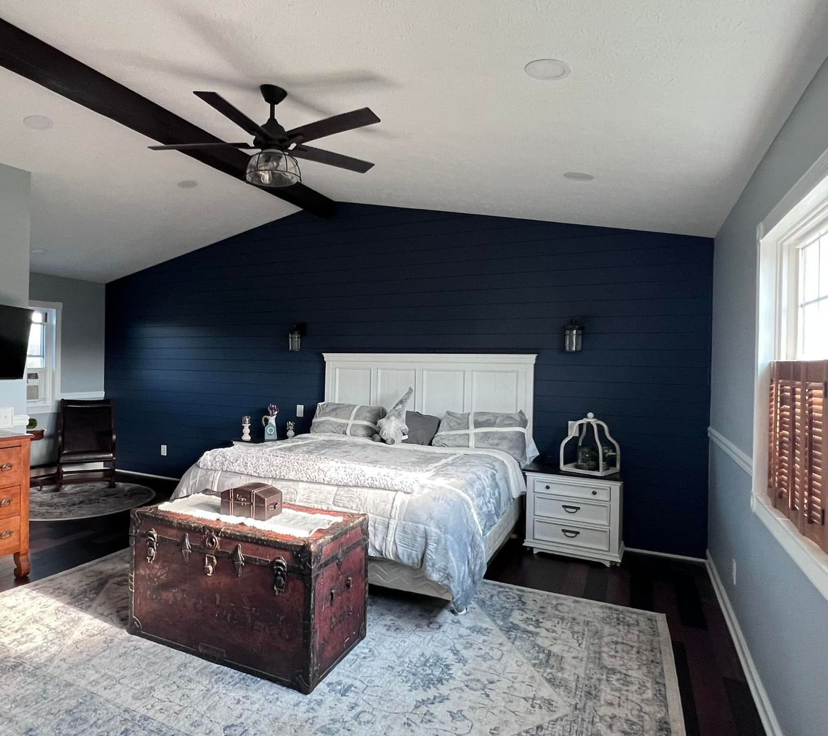A bedroom with a large bed and a ceiling fan