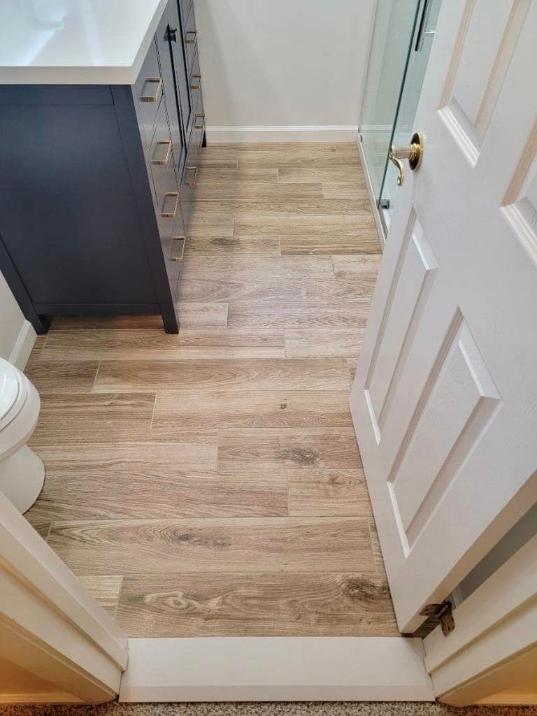 A bathroom with wooden floors and a toilet.
