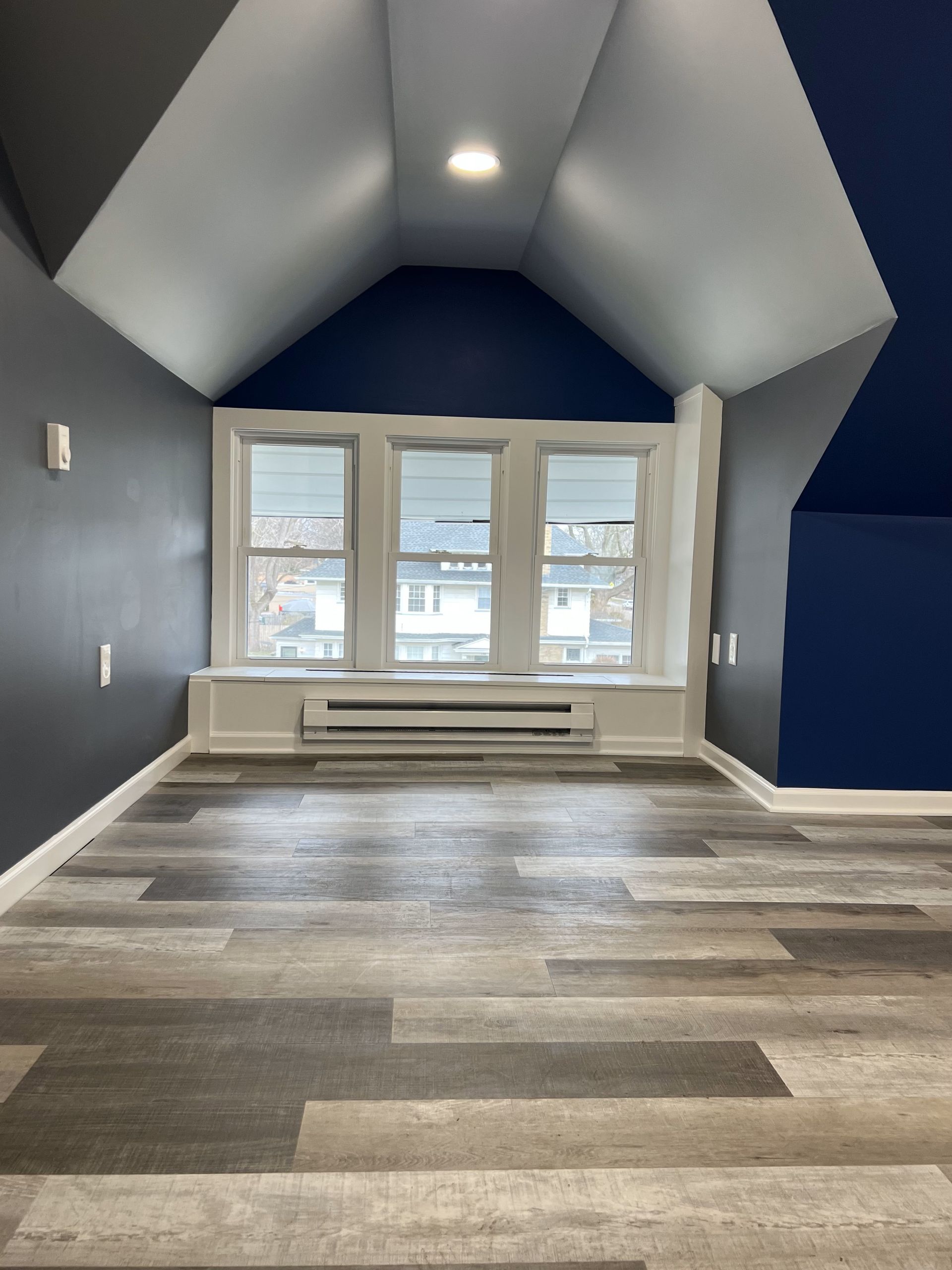 A bedroom with a bed , nightstand , and plant.