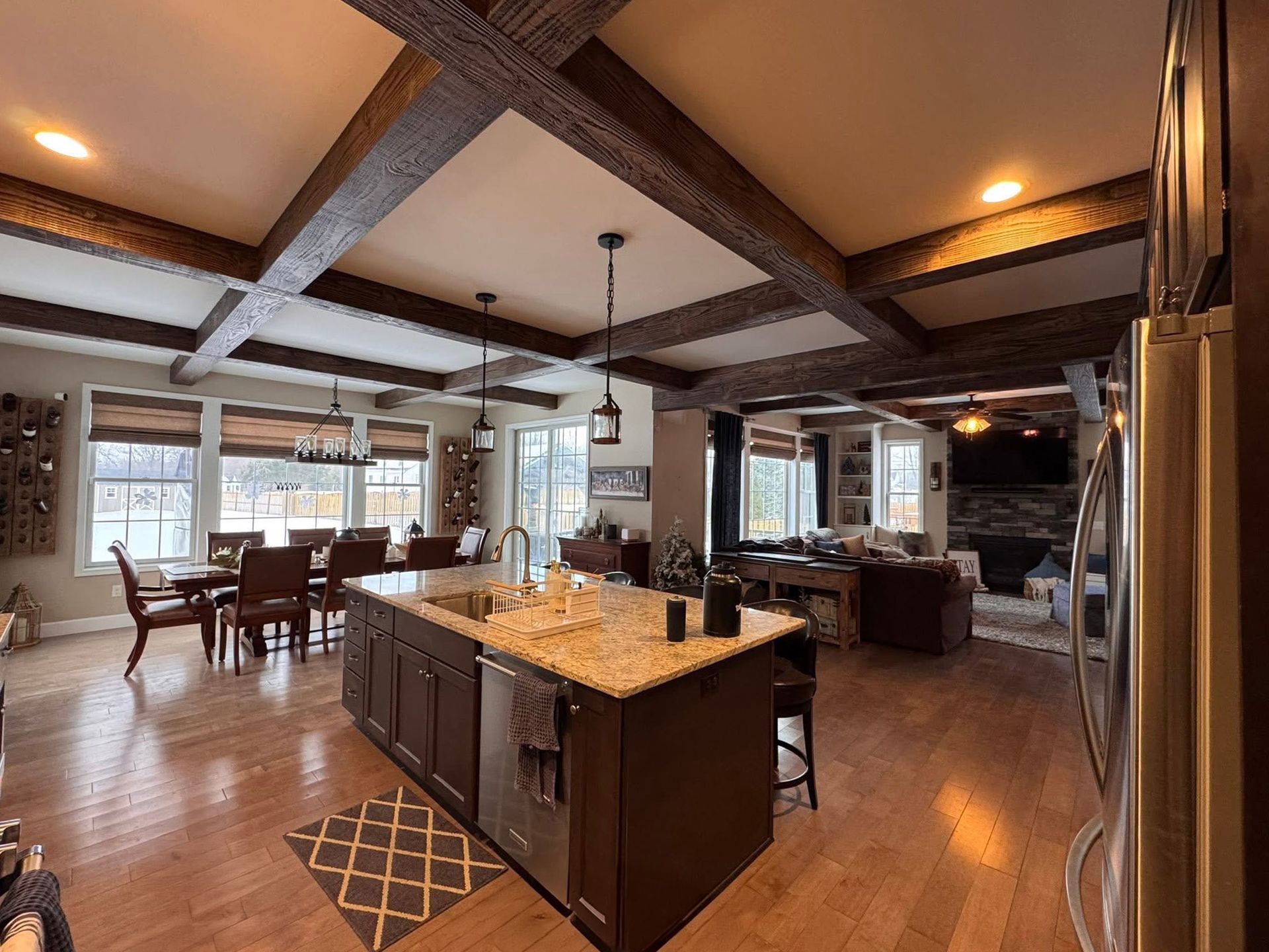 A white house with black shutters is sitting on top of a lush green field.