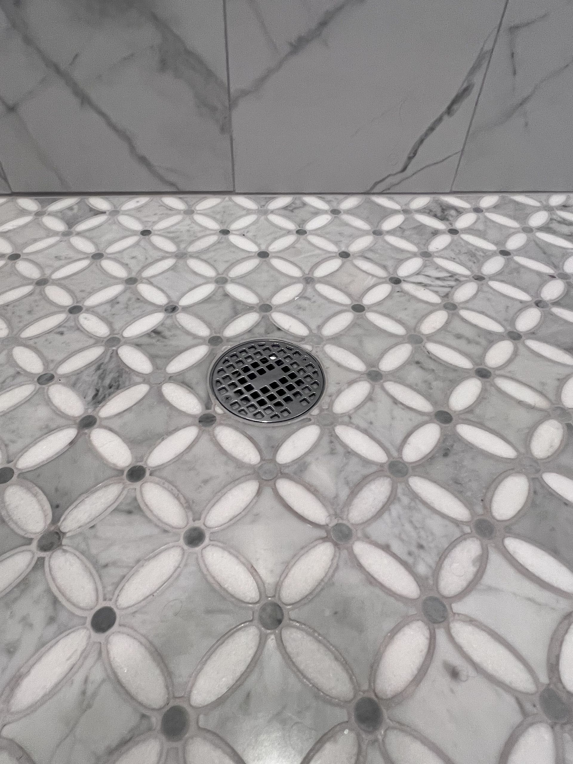 A bathroom with a sink , mirror , and walk in shower.