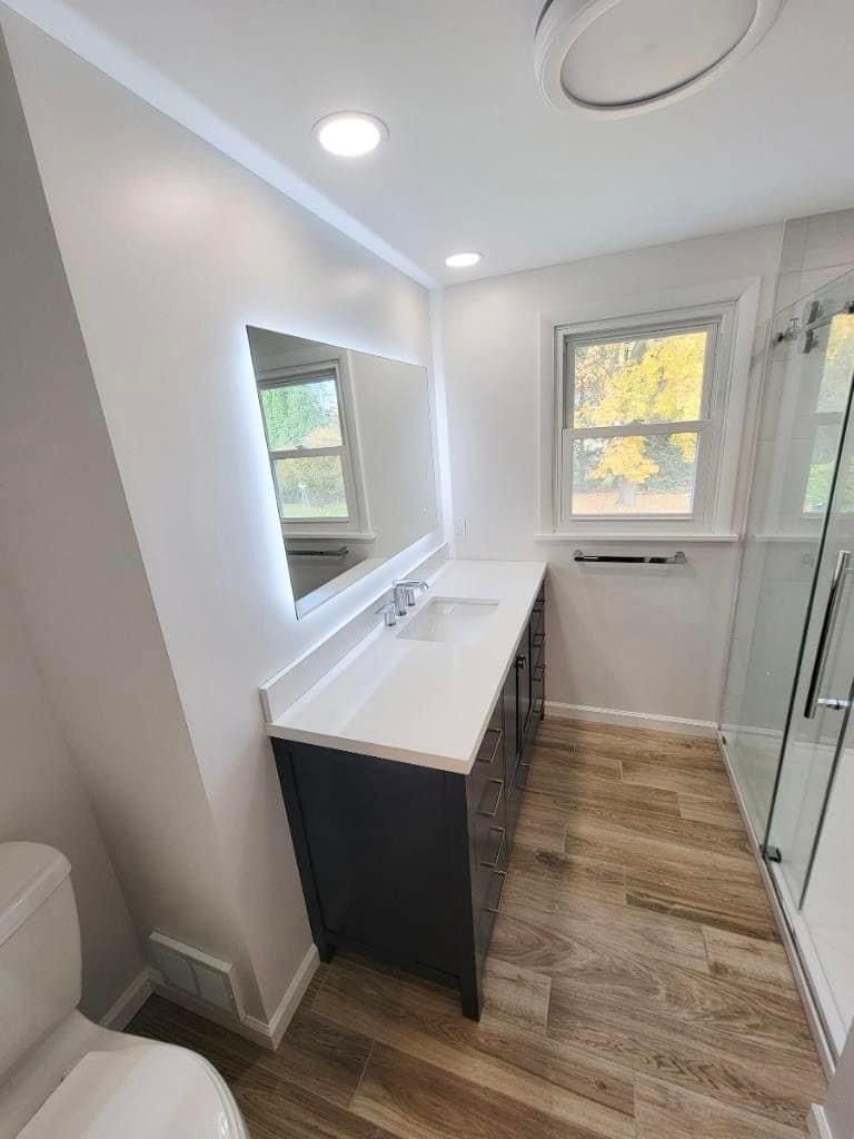 A bedroom with a bed , nightstand , and plant.