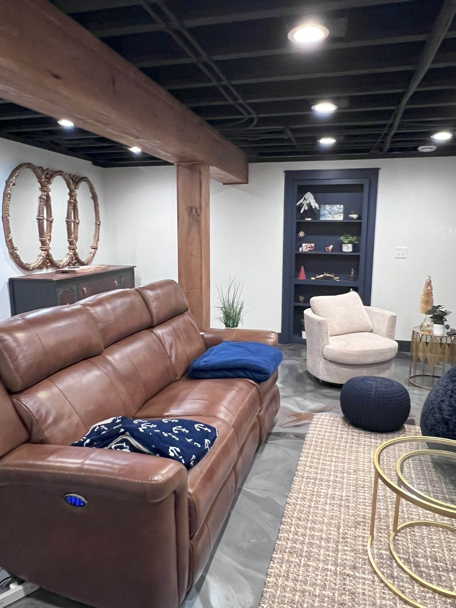 A living room with a couch , coffee table , fireplace and a painting on the wall.