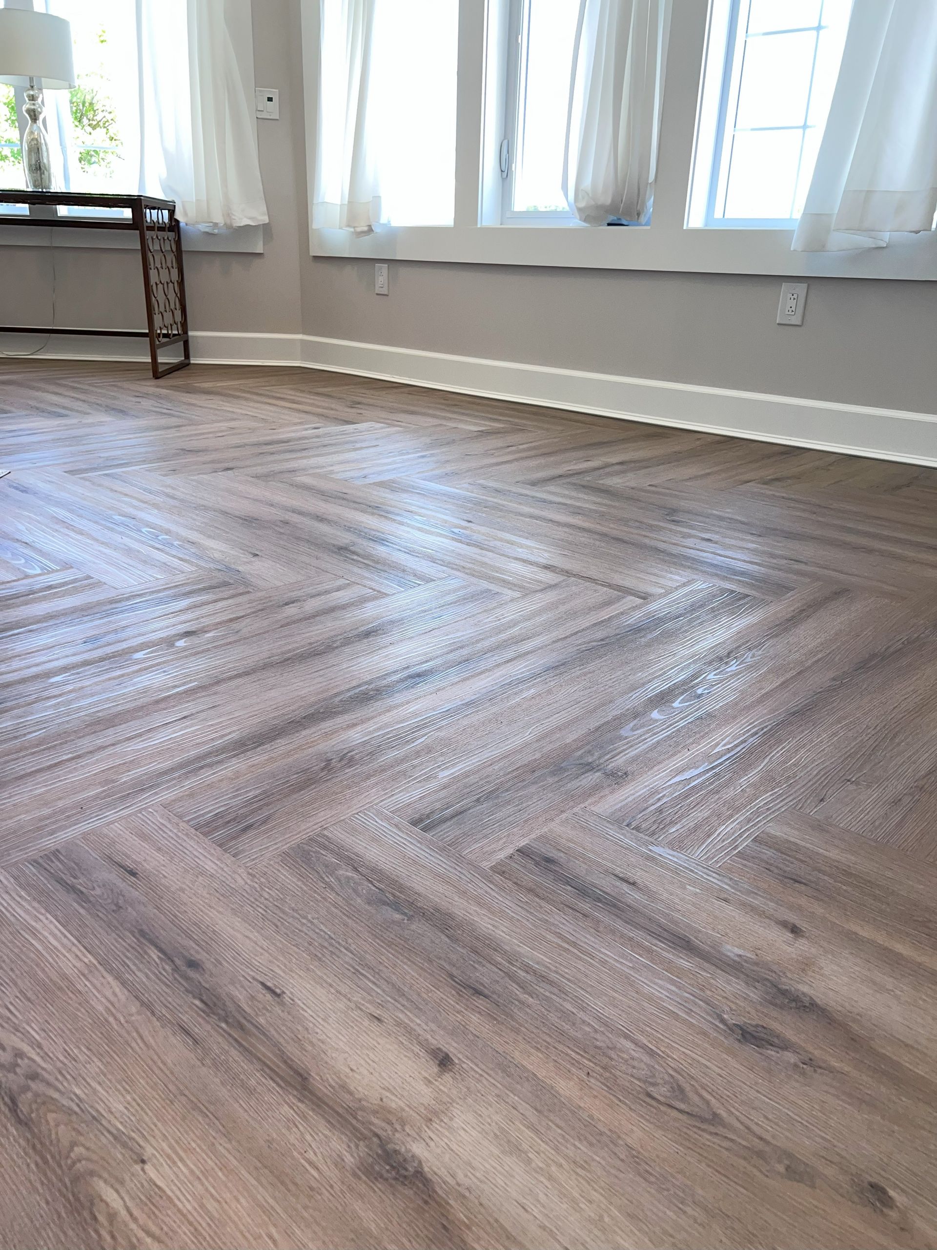 A bedroom with a bed , nightstand , and plant.